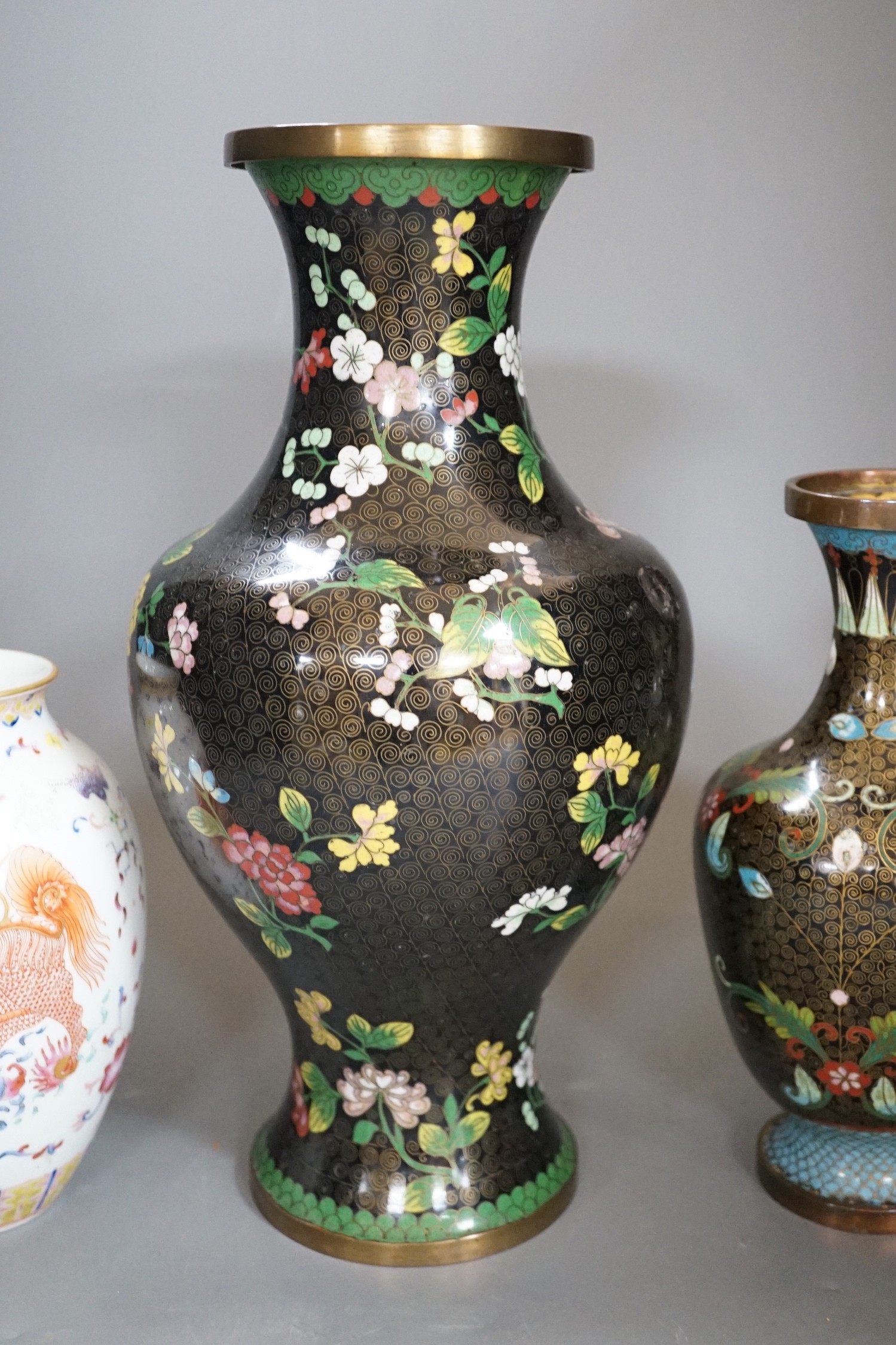 Two Chinese cloisonné enamel vases, and a porcelain ‘lion dog’ vase, tallest 33cm
